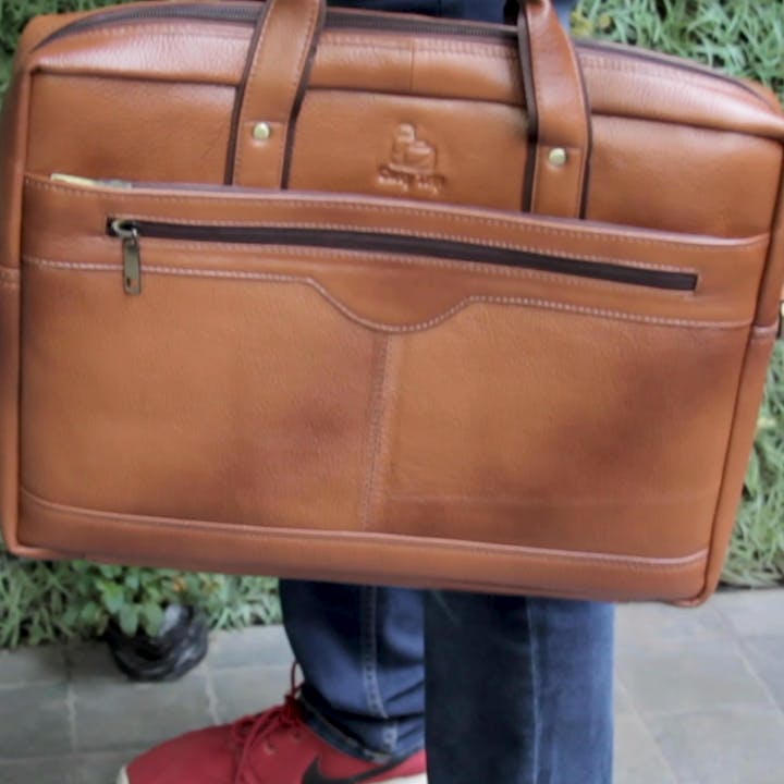Bag,Tan,Brown,Leather,Hand luggage,Beige,Handbag,Orange,Fashion accessory,Vehicle door