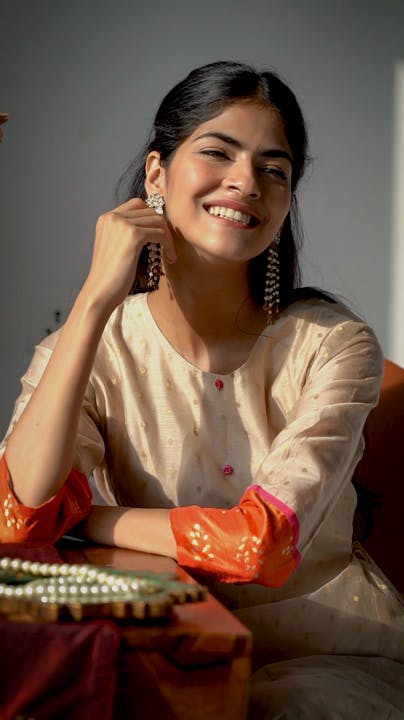 Hair,Skin,Smile,Hand,Arm,Flash photography,Dress,Sleeve,Idiophone,Gesture